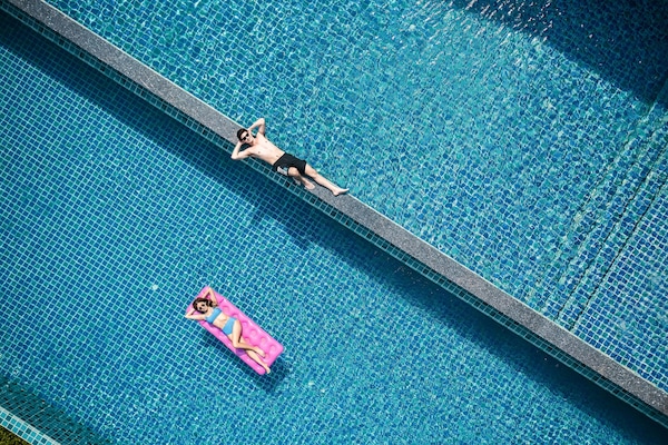 Een buitenzwembad, parasols voor strand/zwembad