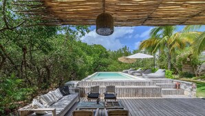 An outdoor deck with a hot tub, wooden furniture, and a pergola. - Vida Silvestre Tulum (Tulum)