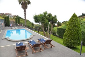 Ein Swimmingpool mit Liegestühlen und einer Hängematte.