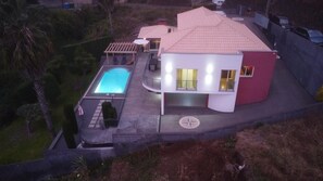 Una casa moderna amb una piscina, un porxo cobert i una secció vermella.