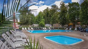 A pool area with multiple lounge chairs and a small pool. - Beautiful private villa for 4 people with WIFI, pool, terrace and pets allowed (Prague)