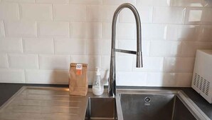 A kitchen with a stainless steel sink, a paper bag, and a bottle of hand soap. - A 2 bedroom gite sleeping 4 plus a cot with access to a heated covered pool. (Henansal)