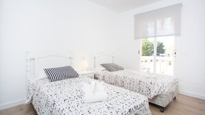 A bedroom with two beds, white walls, a large window, and a ceiling light. - SUN OF THE BAY VIDALBA 1 (B2 - A1) - Apartment with sea views in Port d'Alcudia. Free WiFi (Alc��dia)