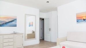 A modern room with a white sofa, a wooden cabinet, and a glass table with a candle. - SUN OF THE BAY VIDALBA 1 (B2 - A1) - Apartment with sea views in Port d'Alcudia. Free WiFi (Alc��dia)
