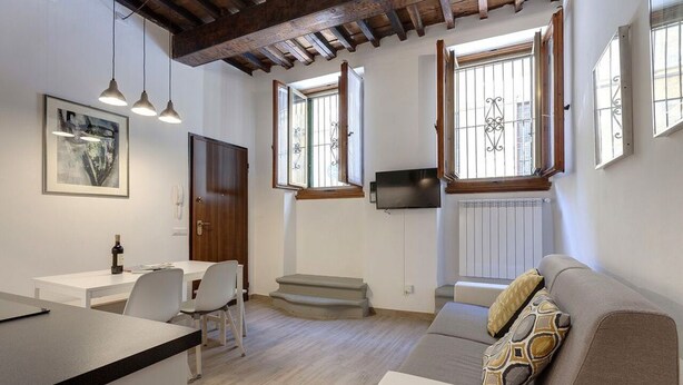 A modern living room with a sofa, a dining area with a table and chairs, and a kitchen area with a counter. - GUELFA HOUSE: restructuring, on the ground floor, comfortably accommodates 6 people  (Firenze)