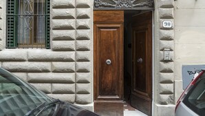 A building entrance with a wooden door, a window with metal bars, and a number sign '90' on the wall. - GUELFA HOUSE: restructuring, on the ground floor, comfortably accommodates 6 people  (Firenze)