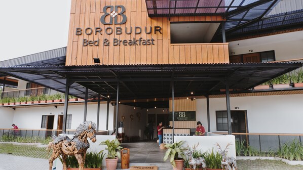 A building with a sign reading "BOROBUDUR Bed & Breakfast" and a covered entrance area with potted plants and decorative horse statues. - Borobudur Bed & Breakfast - Hostel (Mungkid)