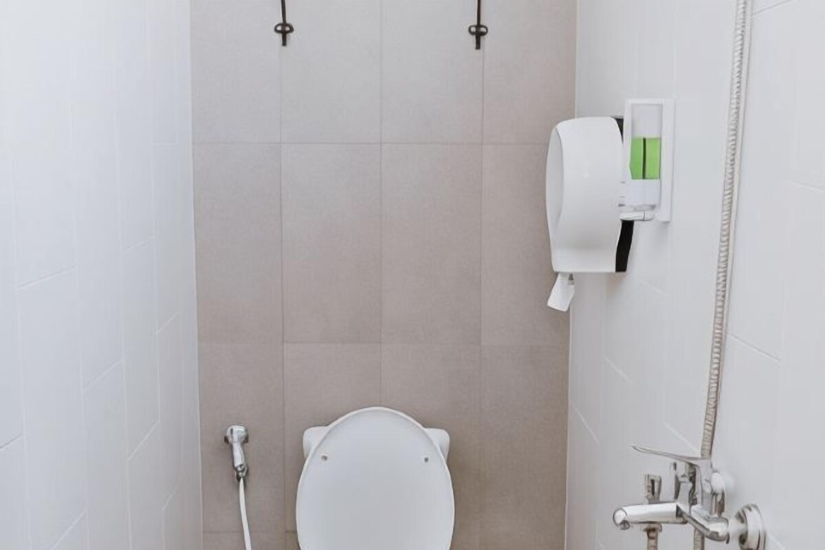 Une salle de bain équipée de toilettes, d’un sèche-mains et d’une douche.