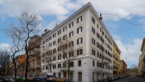 Un edificio a più piani con uno stile architettonico classico, caratterizzato da una facciata simmetrica con finestre regolarmente distanziate e un ingresso centrale.