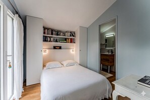Quarto com cama, estante, penteadeira e espelho.