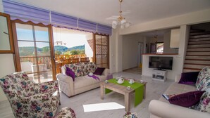 A spacious living room with a sofa, chairs, a coffee table, and a TV. - 5 Bedrooms, heated pool, pool table, table tennis, bbq & wifi. (Mugla)