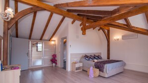 A bedroom with wooden beams, a bed, a nightstand, a dresser, and a door leading to another room. - 5 Bedrooms, heated pool, pool table, table tennis, bbq & wifi. (Mugla)