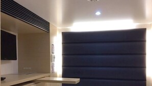 A modern bedroom with a bed, bedside table, and a mounted TV.