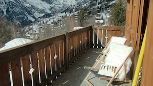A balcony with a wooden railing overlooking a snowy mountain landscape. - 5 star chalet with stunning views, top location, free Wi-Fi, ski-in-ski-out (Bellwald)