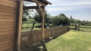 A wooden building with a covered porch and a fenced outdoor area. - Idyllic "witches house" directly on the lake with private jetty (Hohenferchesar)