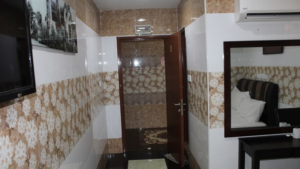 Un baño de hotel con ducha, inodoro, lavamanos y espejo.
