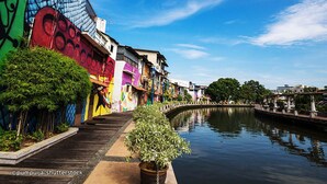 Un canal flanqueado por edificios coloridos y un puente al fondo.