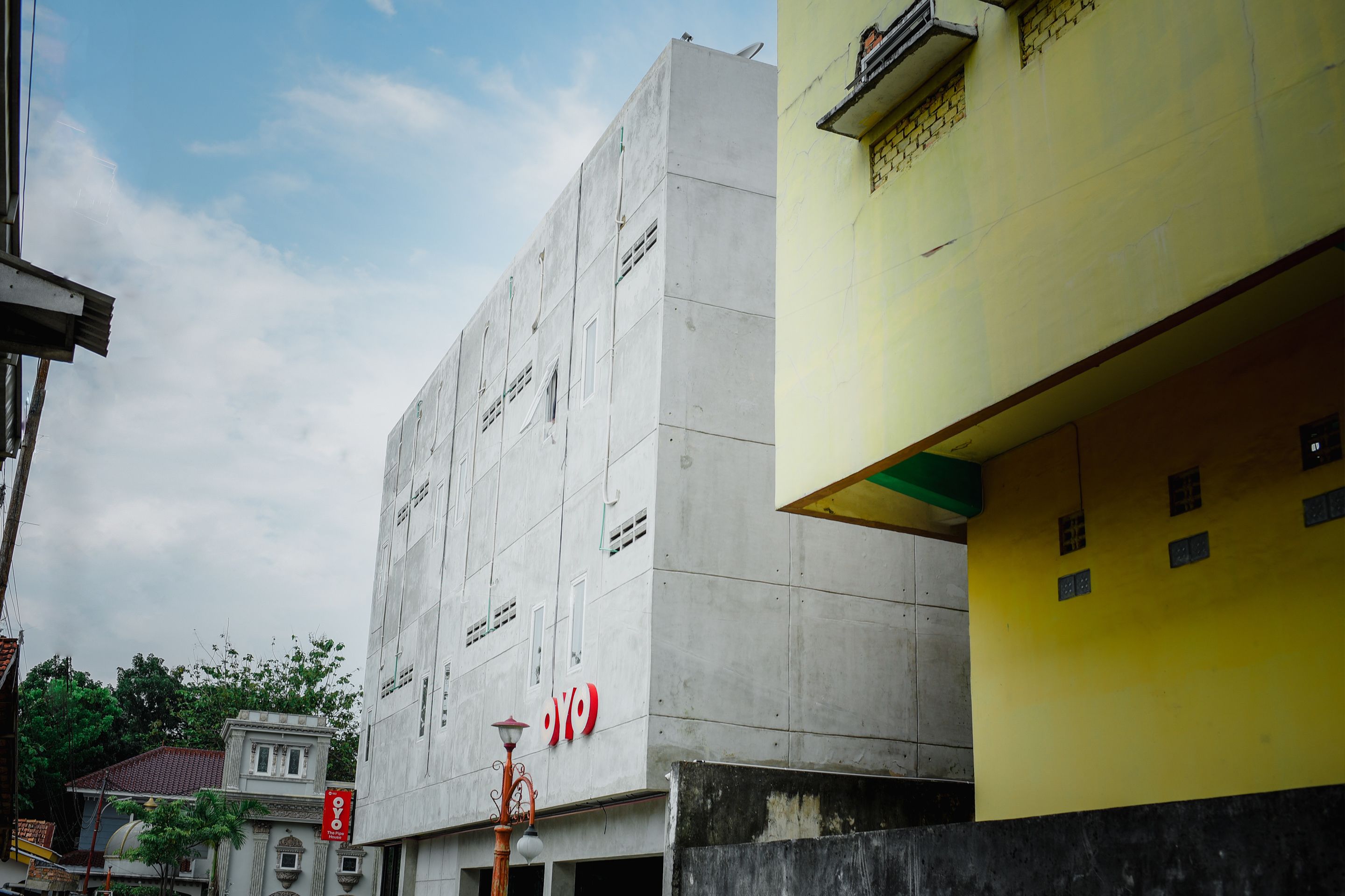 Un bâtiment doté d’une façade en béton et d’une partie jaune sur le côté droit.