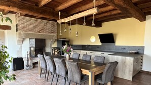 Une cuisine moderne dotée d’un grand îlot central, d’appareils électroménagers intégrés et d’un coin repas avec une longue table et des chaises.