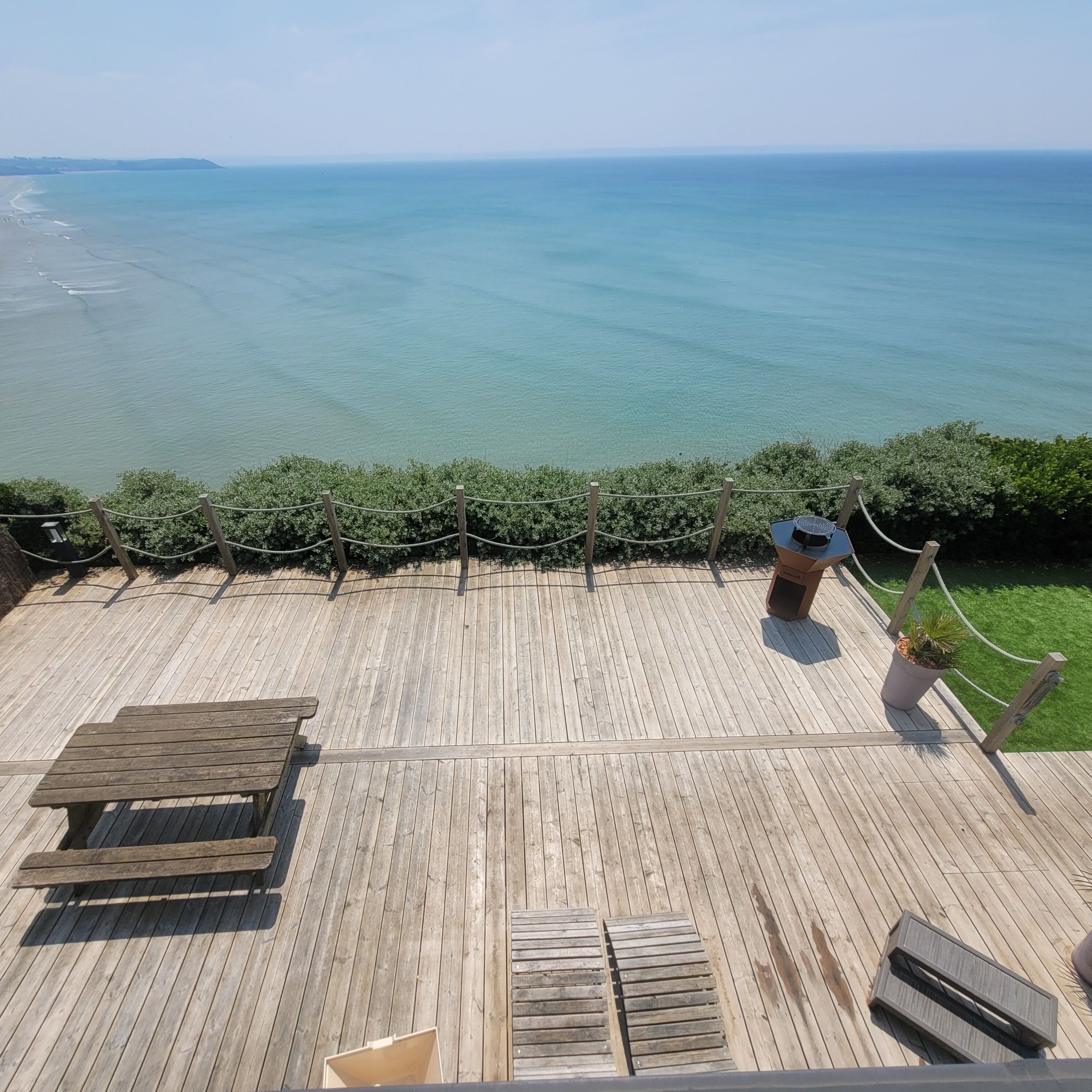 Une terrasse en bois avec vue sur l’océan.