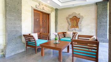 Una habitación con una mesa de madera y cuatro sillas, un adorno en la pared y una puerta de madera grande.