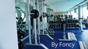 Ein Fitnessstudio mit unterschiedlichen Trainingsgeräten, darunter Kraftgeräte und Kurzhanteln.
