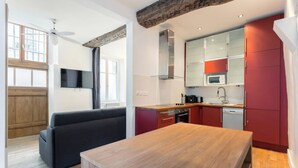 A modern kitchen with a wooden table, red cabinets, and a built-in microwave.