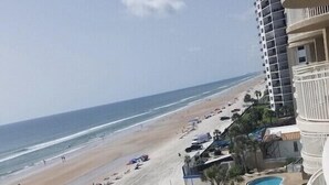 A beachfront hotel with a pool, beach access, and a view of the ocean.