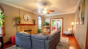 Ein Wohnzimmer mit einer Couch, Kamin und Deckenventilator.