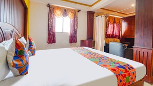 A hotel room with a large bed, a desk, and a chair. - FabHotel Roshan Residency (Kodaikanal)