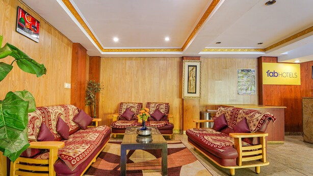 A lobby with two sofas, a coffee table, and a reception desk. - FabHotel Roshan Residency (Kodaikanal)