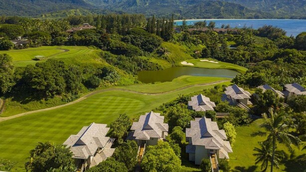 Un parcours de golf offrant une vue sur les montagnes et un plan d’eau.