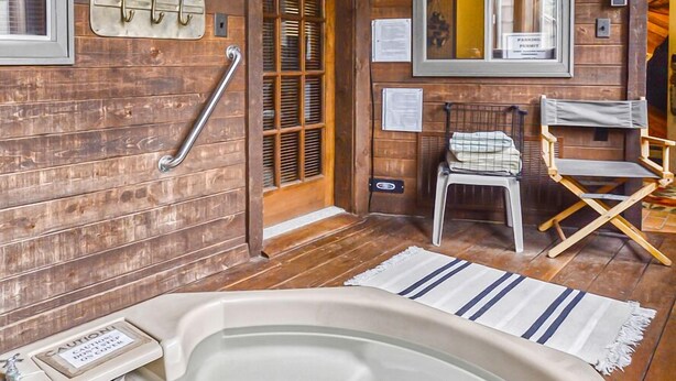 A wooden cabin interior with a hot tub, a wooden ceiling, a mirror, and a door. - Large Beautiful Townhome, Private Hot Tub, Near Shuttle Route, In Town, WIFI (Winter Park)