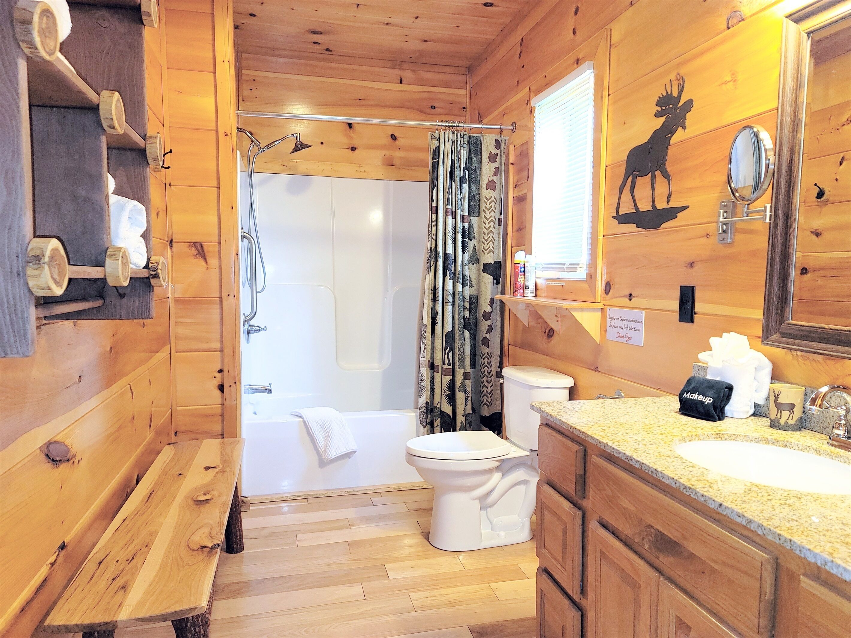 A wooden cabin bathroom with a shower, toilet, and sink.