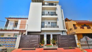 A multi-story residential building with a gated entrance, balconies, and a flat roof. - Hotel Aarya (Lucknow)