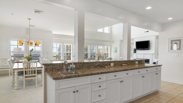A spacious kitchen with white cabinetry, a granite countertop, and a large island. - Sea Lookout - Great last-minute rates with ocean views. June 27-July 4! (Atlantic Beach)