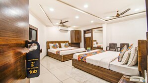 A hotel room with two beds, a desk, a phone, a mirror, and a ceiling fan. - FabHotel Rajnandani Residency - Bhanwarkuan (Indore)
