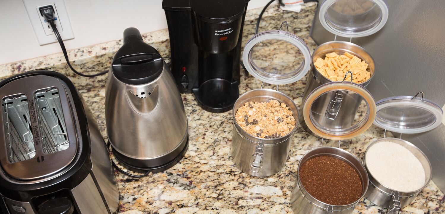 Una encimera de cocina con diferentes electrodomésticos y recipientes.