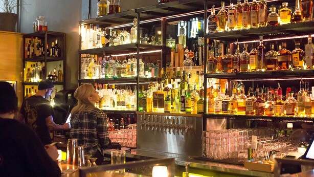 A bar area with shelves of various liquor bottles and glasses. - Multnomah Gem - Beautiful, pampering, mins to downtown Portland (Portland)