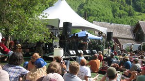 Un evento al aire libre concurrido, con escenario y público.