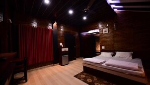 A hotel room with a wooden ceiling, a bed with white linens, a small bedside table, and a red curtain. - Scorpio Clubs & Resorts (Bakshi Ka Talab)