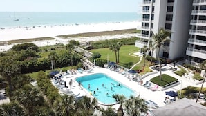 A hotel with a pool surrounded by palm trees and a view of the beach. - Direct Gulf Of America Views! (Marco Island)