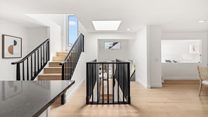 A modern interior with a staircase, a dining area, and a kitchen. - Ventura Beach House with Ocean View (Ventura)