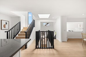Um interior moderno com escada, área de jantar e cozinha.