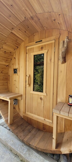 A wooden sauna with a door, a bench, and a control panel. - Welcome to Sacred Pilgrimage Studio with Garden View. Pet-Friendly! (Victoria)