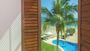 A room with a large sliding glass door leading to a pool area with palm trees and a view of the ocean. - Punta Mita Beachfront 5 star Luxury•Incredible VIEWS•PREMIER Membrsp. Golf Cart (Punta Mita)