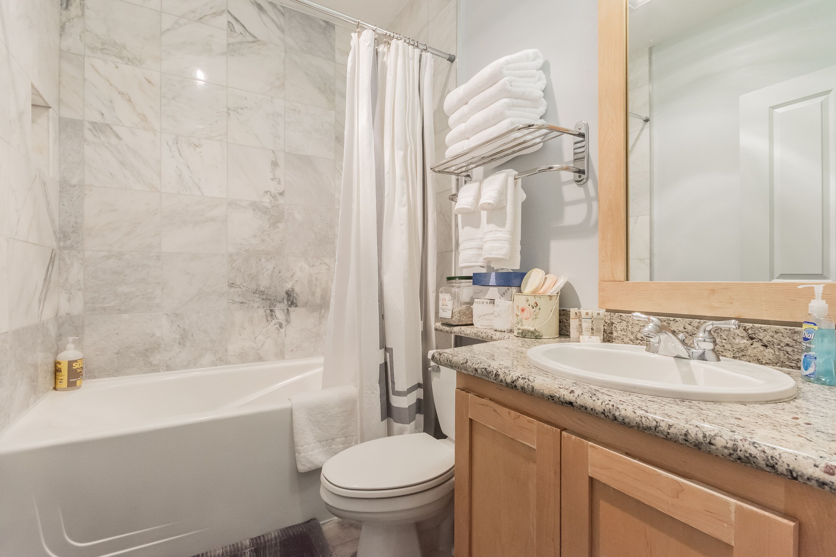 A bathroom with a bathtub, toilet, and sink.