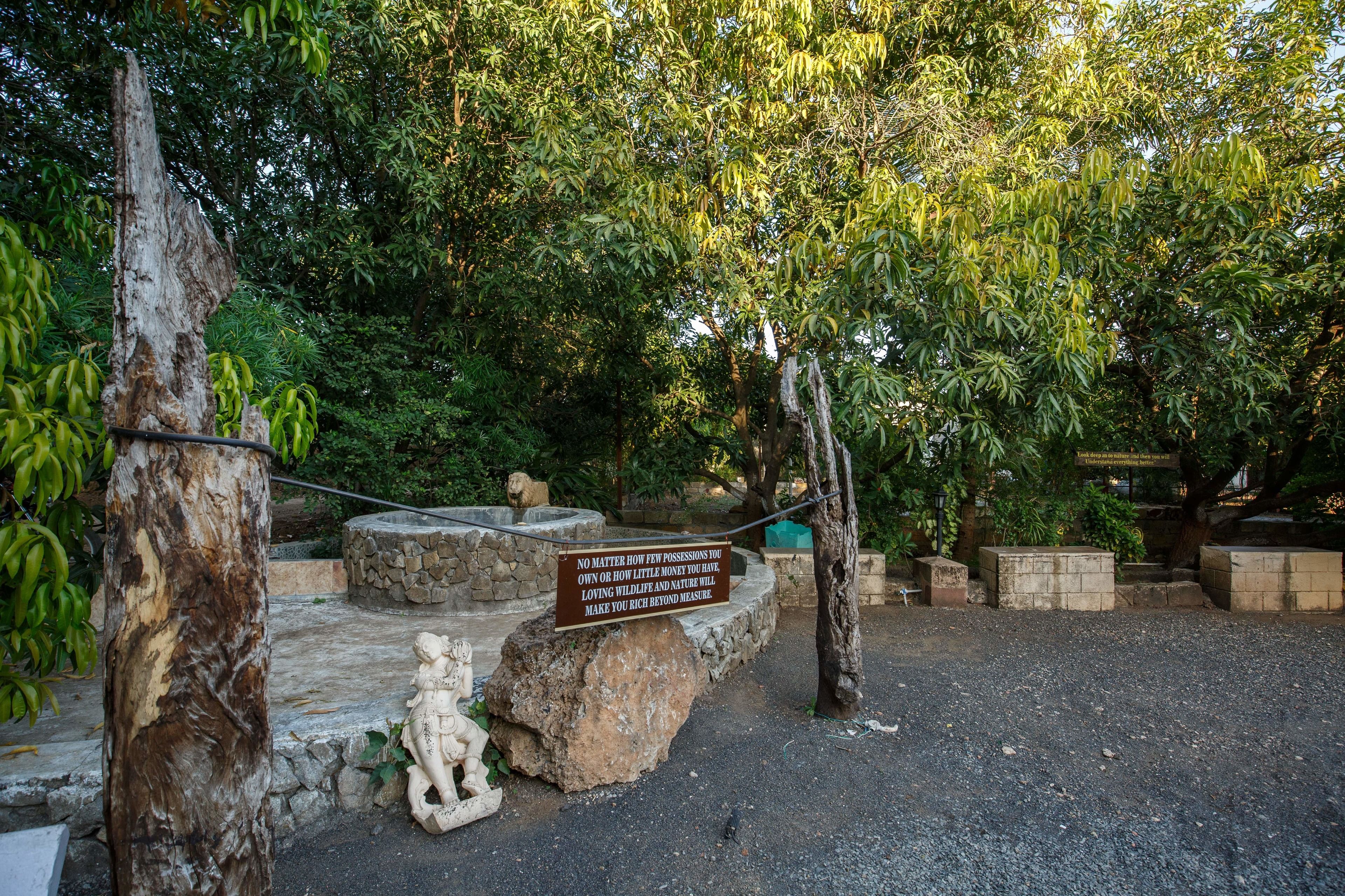A stone pathway leading to a seating area with a signboard.