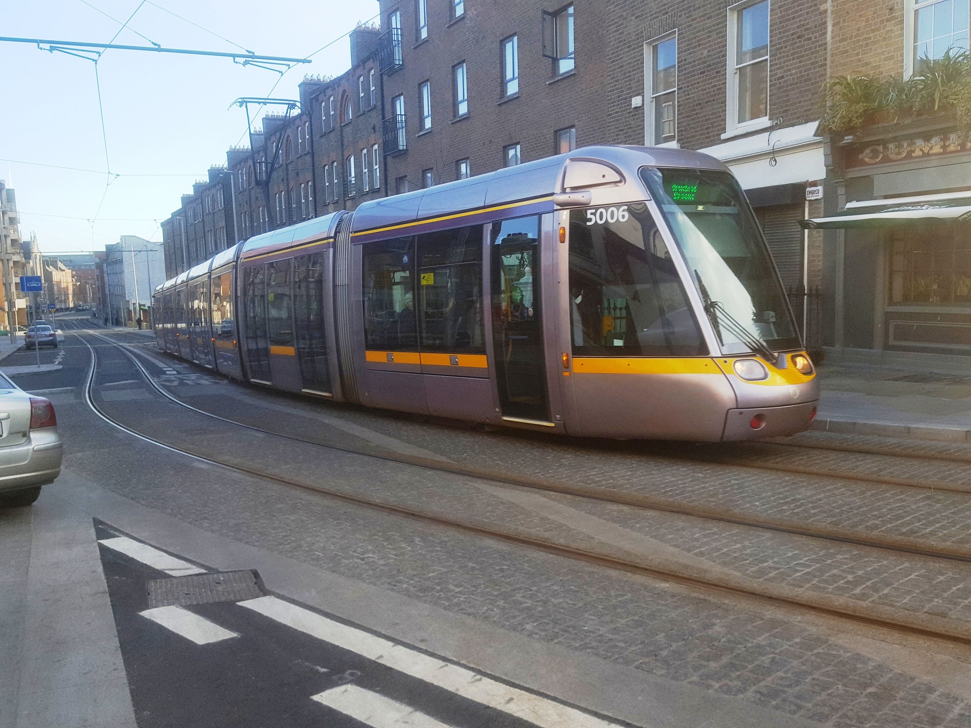 Un tramway moderne portant le numéro 5006, circulant dans une rue de la ville.