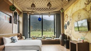 A hotel room with two beds, a large window with a view of a green landscape, a map on the wall, and a TV on a stand. - The Dawn B&B (Ji'an)